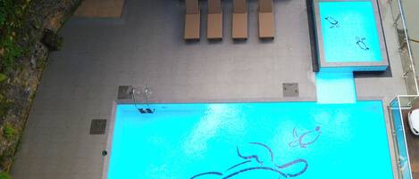 Una piscina al aire libre, tumbonas