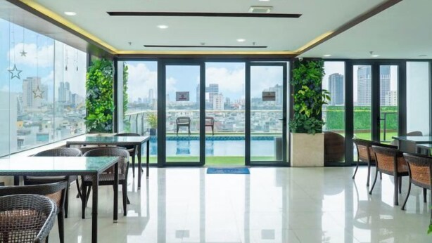 Zona pranzo moderna con pareti in vetro, vista piscina e sullo skyline della città.