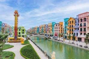 A canal with colorful buildings, a bridge, and a tall structure. - Homestay SWAN BY KAT (Nghia Tru)