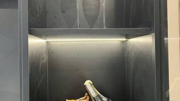 En elevator med en champagneflaske og to glas på øverste hylde.