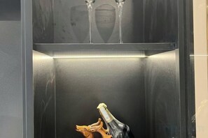 An elevator with a bottle of champagne and two glasses on the top shelf. - Homestay SWAN BY KAT (Nghia Tru)