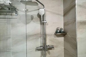 A modern shower with a handheld showerhead and a wall-mounted control panel. - Homestay SWAN BY KAT (Nghia Tru)