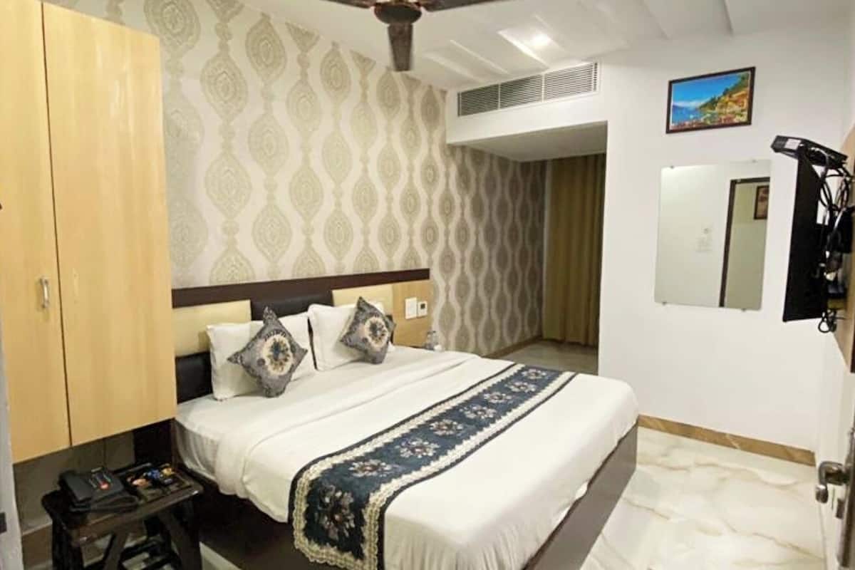 Une chambre à coucher comprenant un lit, une armoire, un ventilateur de plafond et une petite table.