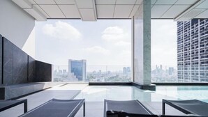 A rooftop pool area with lounge chairs, a clear view of the city skyline, and a modern architectural design. - Loft Apartments in Bangkok near Jodd Night Market [Nearly 711+ Central Pharam 9 Shopping Center] (Bangkok)