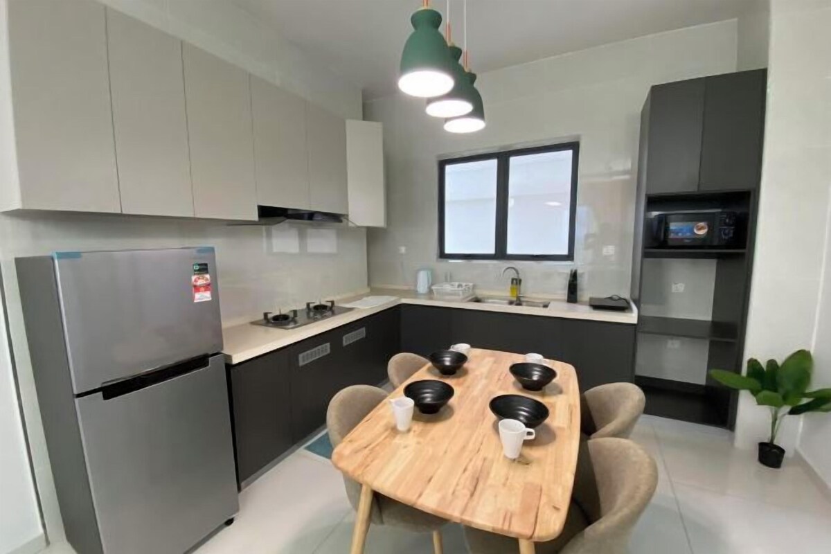 A modern kitchen with a built-in refrigerator, a dining table with chairs, a window, and a microwave.