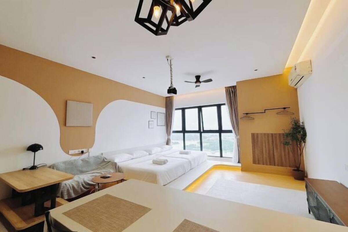 A modern hotel room with a bed, a desk, a chair, a ceiling fan, and a large window.