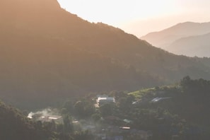 A mountainous landscape with a valley and scattered buildings. - Bon r kaad (Mae Rim)