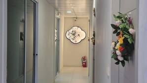 A hallway with a fire extinguisher, a wall-mounted decorative piece, and a door on the left. - Rock Resort Koh Larn (Koh Larn)