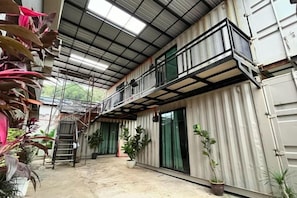 A multi-level building with a balcony, potted plants, and a ladder. - Tc Theme Park Guest House (Kuala Kuantan)