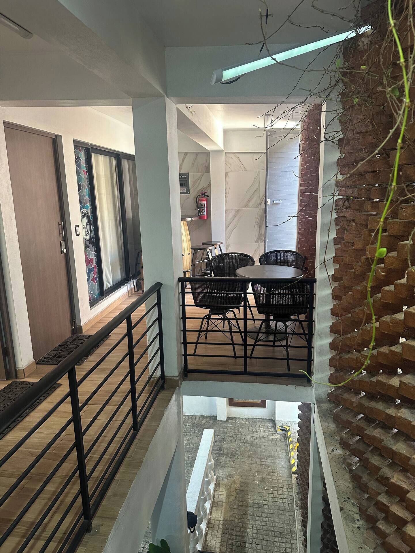Un interior moderno con comedor, escalera y vistas al exterior.