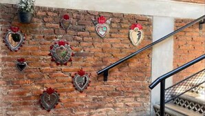 A brick wall with heart-shaped decorations and a staircase with a patterned floor. - The best view of the river & apartament's garden (Orizaba)