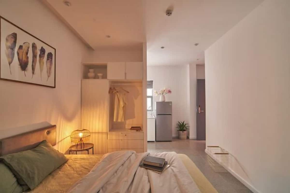 Ein Schlafzimmer mit Bett, Nachttisch und einem an der Wand hängenden Kunstwerk.