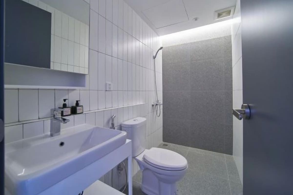Een badkamer met wastafel, toilet en douche.