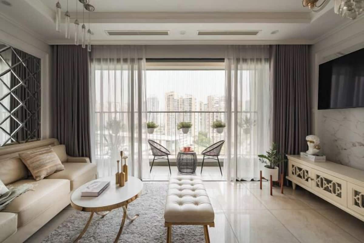 Ein modernes Wohnzimmer mit Sofa, Couchtisch, Bank und einem Balkon mit Stühlen und Pflanzen.