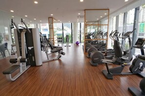 A gym with cardio machines, weight stations, and a mirrored wall. - Luxury Seaview Landmark Homestay at Gurney (Tanjung Tokong)