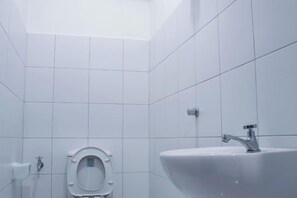 A bathroom with a toilet, sink, and tiled walls. - Luxury Seaview Landmark Homestay at Gurney (Tanjung Tokong)