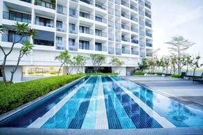 A modern hotel with a long swimming pool, a white facade, and a structured balcony design. - Luxury Seaview Landmark Homestay at Gurney (Tanjung Tokong)