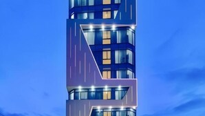A modern building with a unique angular design, featuring multiple levels and large windows. - Diamond Beach Hotel (Da Nang Municipality)