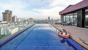 A rooftop infinity pool with a city view, wooden deck, and lounge chairs. - Diamond Beach Hotel (Da Nang Municipality)