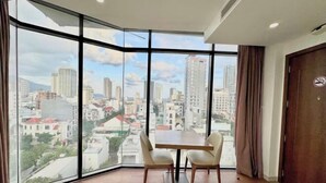A corner room with a large window offering a city view. - Diamond Beach Hotel (Da Nang Municipality)
