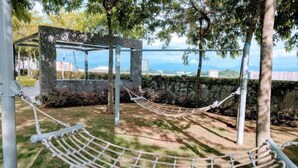 A hammock set up in a garden area with a view of the cityscape. - Utopian Residence IMAGO Mall KK (Kota Kinabalu)