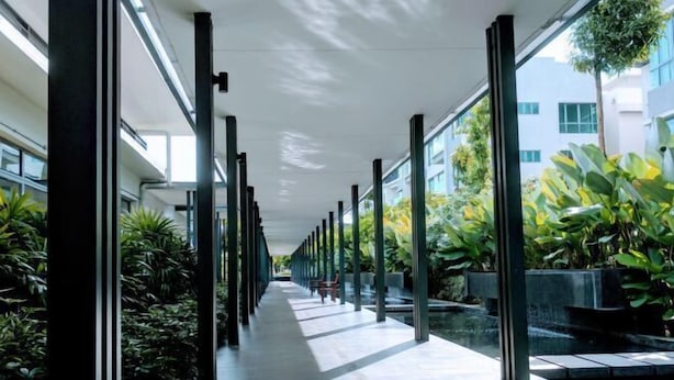 A corridor with a glass wall on one side, allowing views of the outside. - Utopian Residence IMAGO Mall KK (Kota Kinabalu)