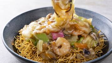 A bowl of noodles with shrimp and vegetables.