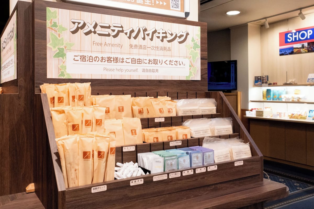 Een bad/douchecombinatie, een haardroger, pantoffels, handdoeken