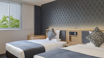 Une chambre d’hôtel avec deux lits, une fenêtre donnant sur la verdure, un mur décoré d’un motif et un panneau de commande sur la tête de lit.