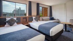 A hotel room with two beds, a sofa, a small table, and large windows with curtains. - ART HOTEL Sasebo Central (Sasebo)