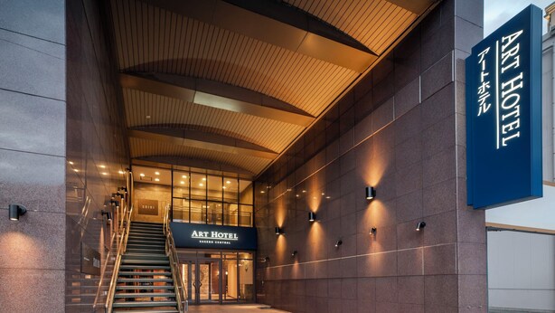 The Art Hotel entrance with a staircase leading up to the doors, a modern architectural design, and a signboard. - ART HOTEL Sasebo Central (Sasebo)