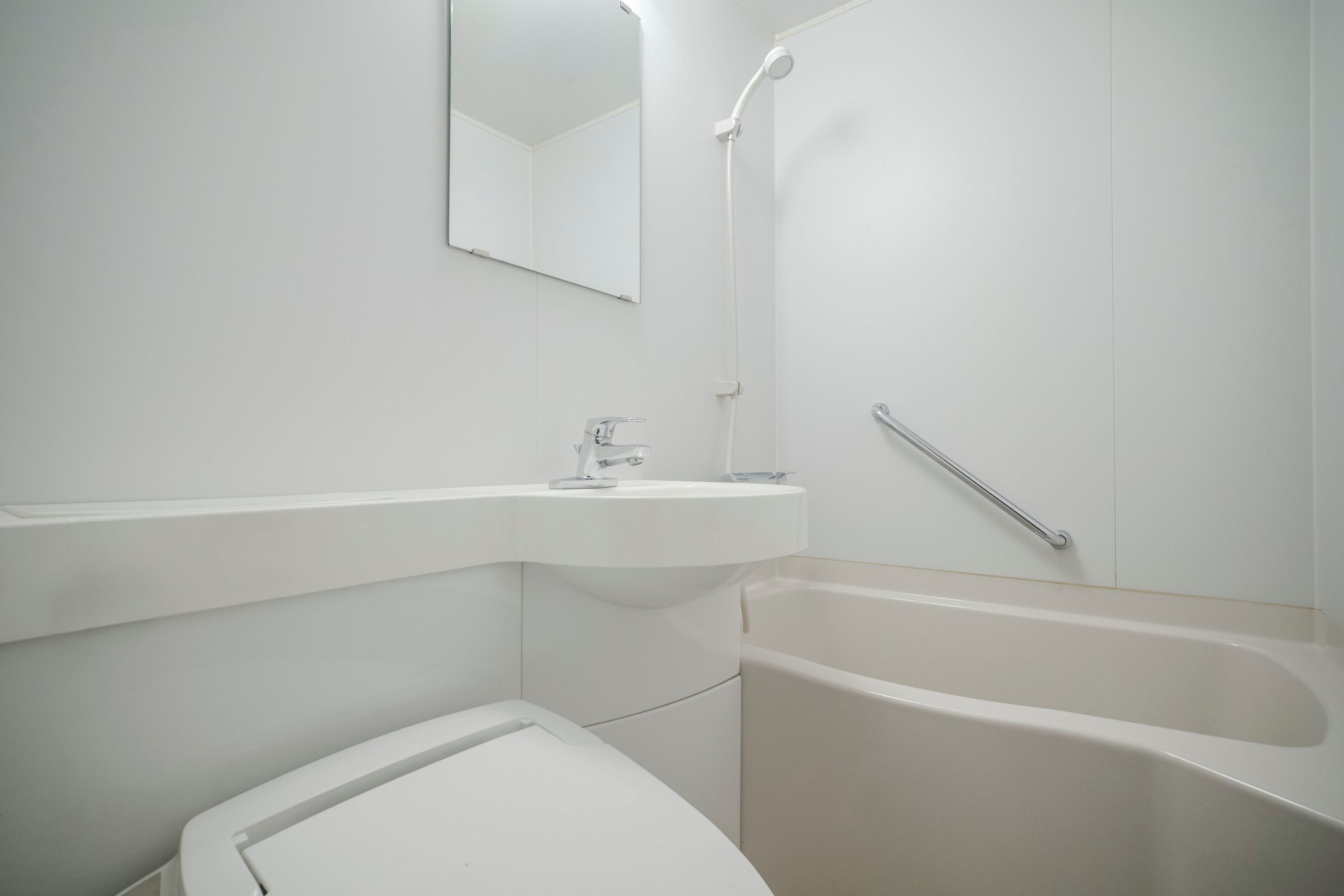 Un baño con lavamanos, espejo, ducha y bañera.