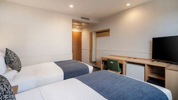 A hotel room with two beds, a desk, a television, and a mirror.