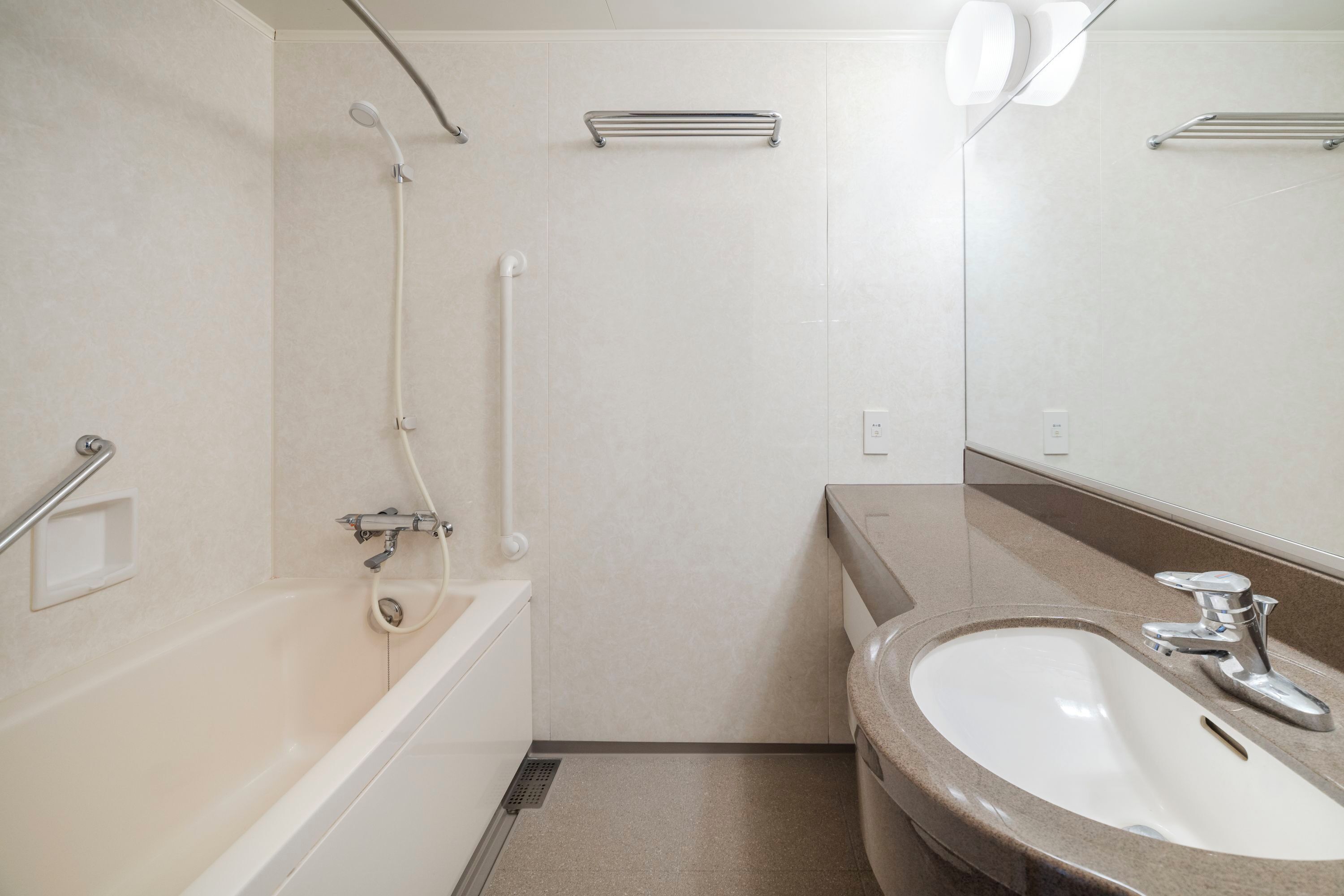 A bathroom with a bathtub, a sink, a mirror, and a shower.