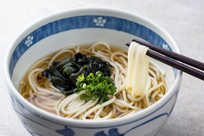 A bowl of noodles with chopsticks, garnished with green onions and seaweed. - ART HOTEL Sasebo Central (Sasebo)
