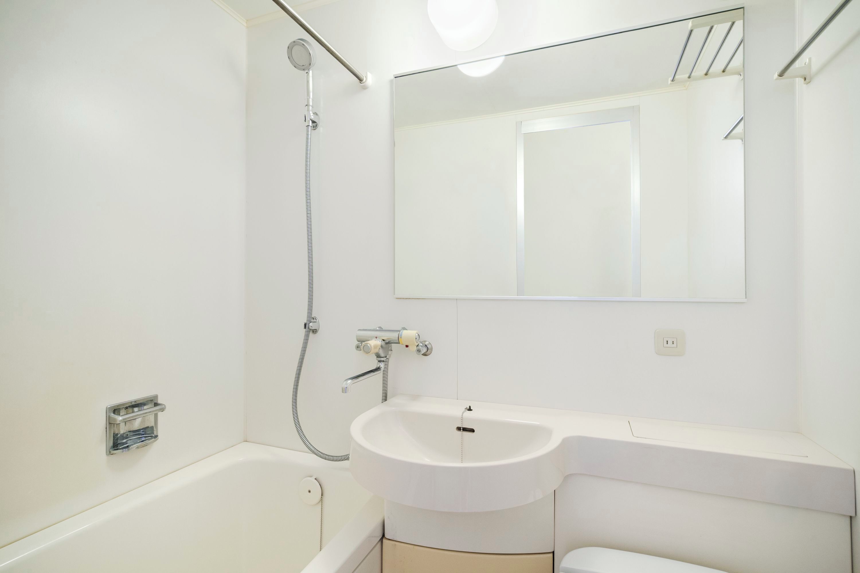 A modern bathroom with a bathtub, a sink, and a mirror.