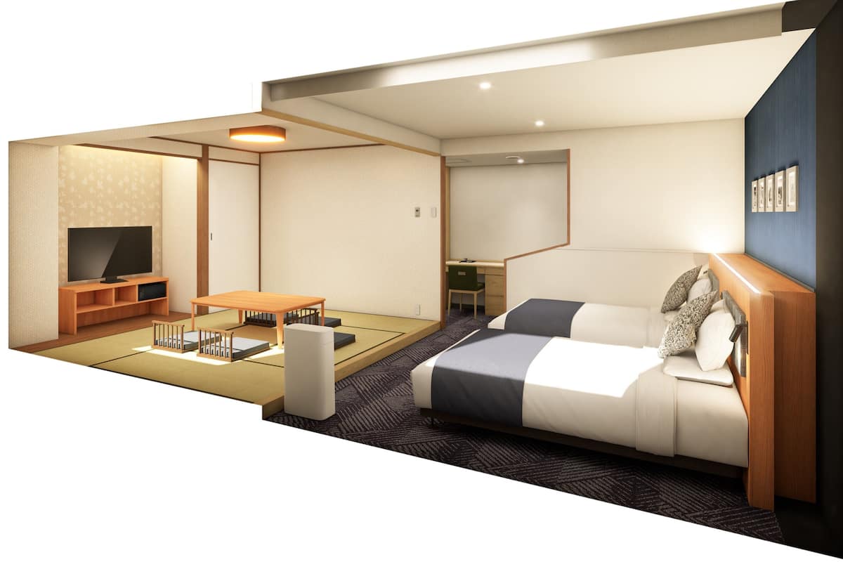A hotel room with a sofa bed, a TV, a small table, and a desk.