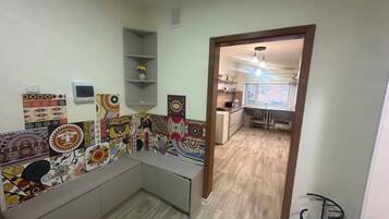 A room with a kitchen area, a dining table, and a built-in bench.