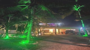 A building with a covered entrance and a car parked in front. - Avila's Hostel Moalboal (Moalboal)
