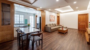 Una sala de estar moderna con comedor, suelo de madera y un ventanal que proporciona luz natural.