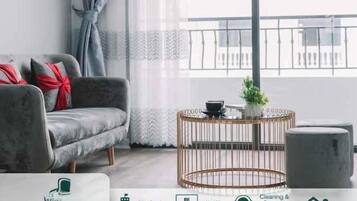 A modern living room with a grey sofa, a round coffee table, and a view of the city center.