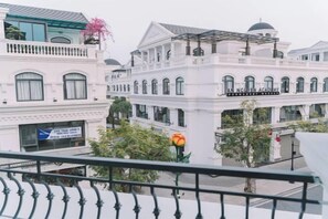 A multi-story building with a classical architectural style, featuring a balcony and a sign that reads 'AN NCOLEAN ACADEMY.'
