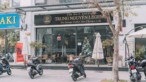 A building with a sign for 'TRUNG NGUYEN LEGND' cafe, outdoor seating, and parked scooters. - Merci Vinhomes Marina Hai Phong (Haiphong)
