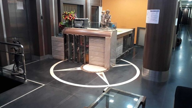 A reception area with a marble counter, a glass table, and a statue. - Hotel Rourkela Palace (Rourkela)