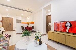 A modern living room with a flat-screen TV, a dining area, and a sofa. - An Corner - Sunwah Pearl Apartment (Ho Chi Minh City)