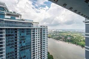 Un immeuble de grande hauteur offrant une vue sur le fleuve, doté d’une architecture moderne et surplombant un ciel dégagé.