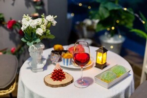A table with a glass of red wine, a small lantern, and various food items. - An Corner - Sunwah Pearl Apartment (Ho Chi Minh City)