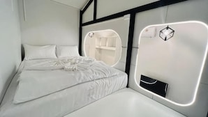 A modern bedroom with a bed, bedside tables, and built-in lighting.