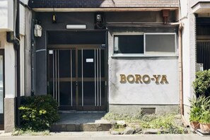 Entrada de un edificio con puerta de vidrio y un letrero que dice 'BORO-YA'.