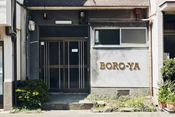 A building entrance with a glass door and a sign reading 'BORO-YA'.